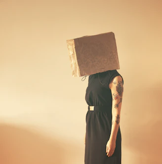 person in black sleeveless dress covered by paper bag