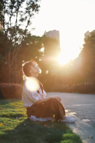 A peaceful student practicing mindfulness outdoors on campus during sunset.