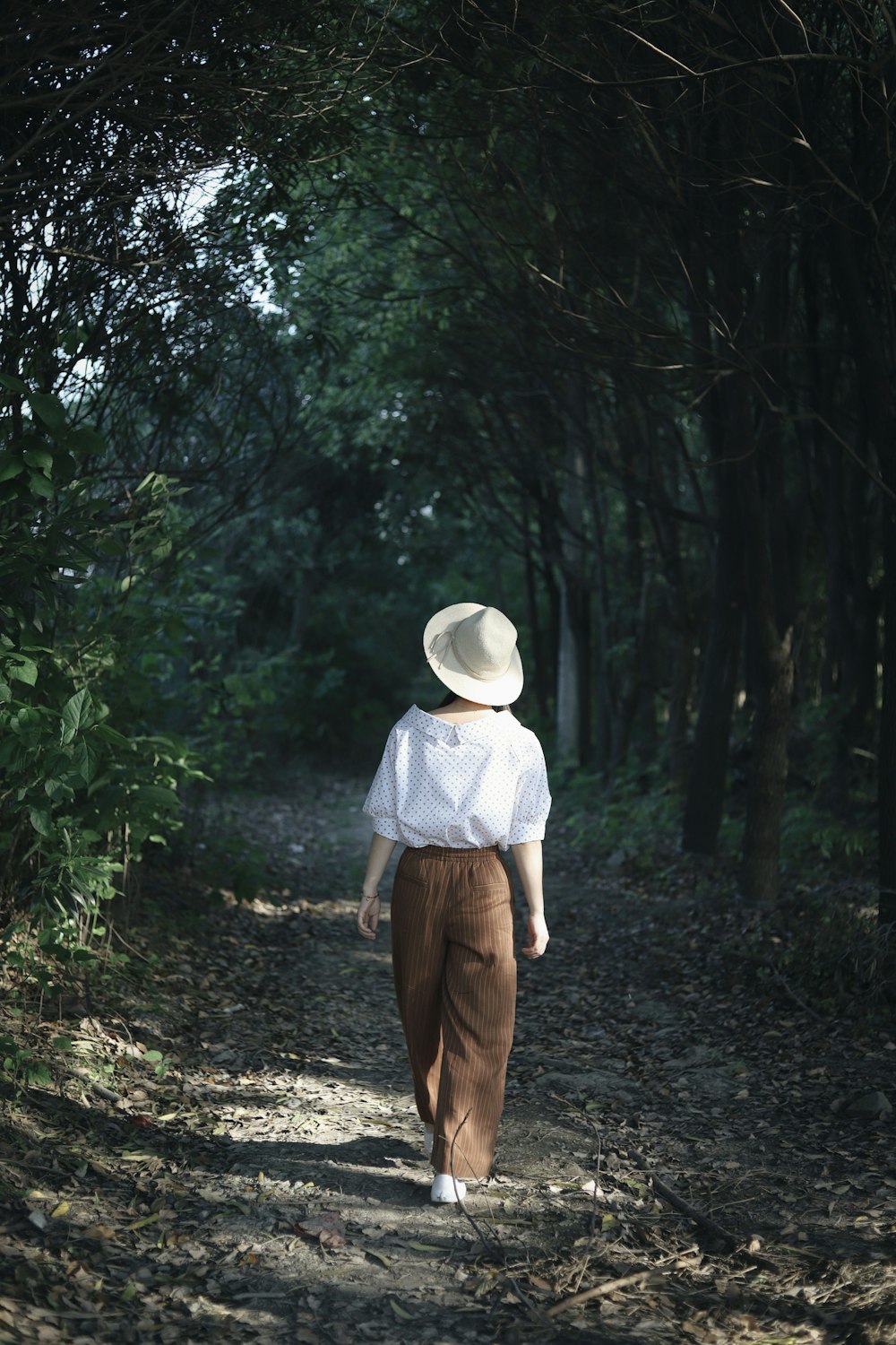 woman wearing cap standing near trees