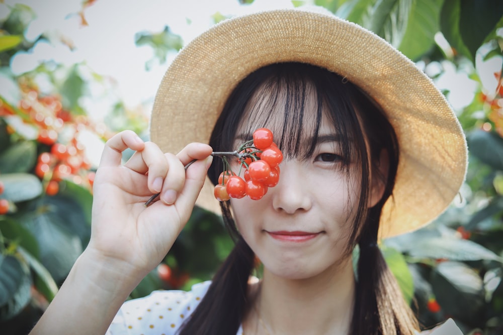 Mujer sosteniendo frutas redondas de naranja
