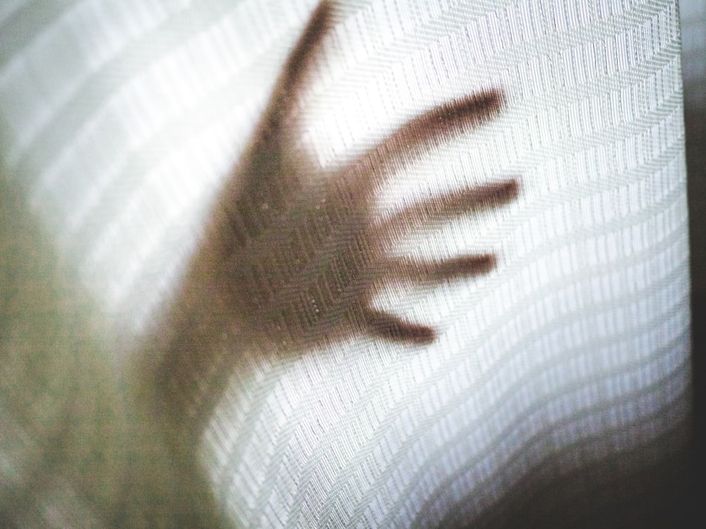 a blurry image of a hand coming out of a window