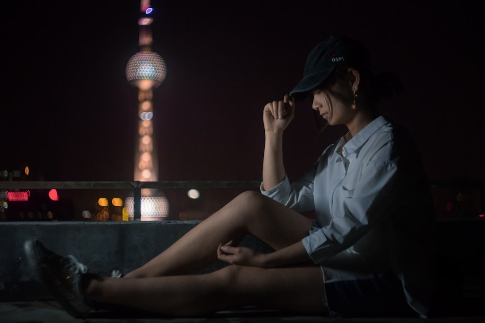 woman wearing cap leaning on wall