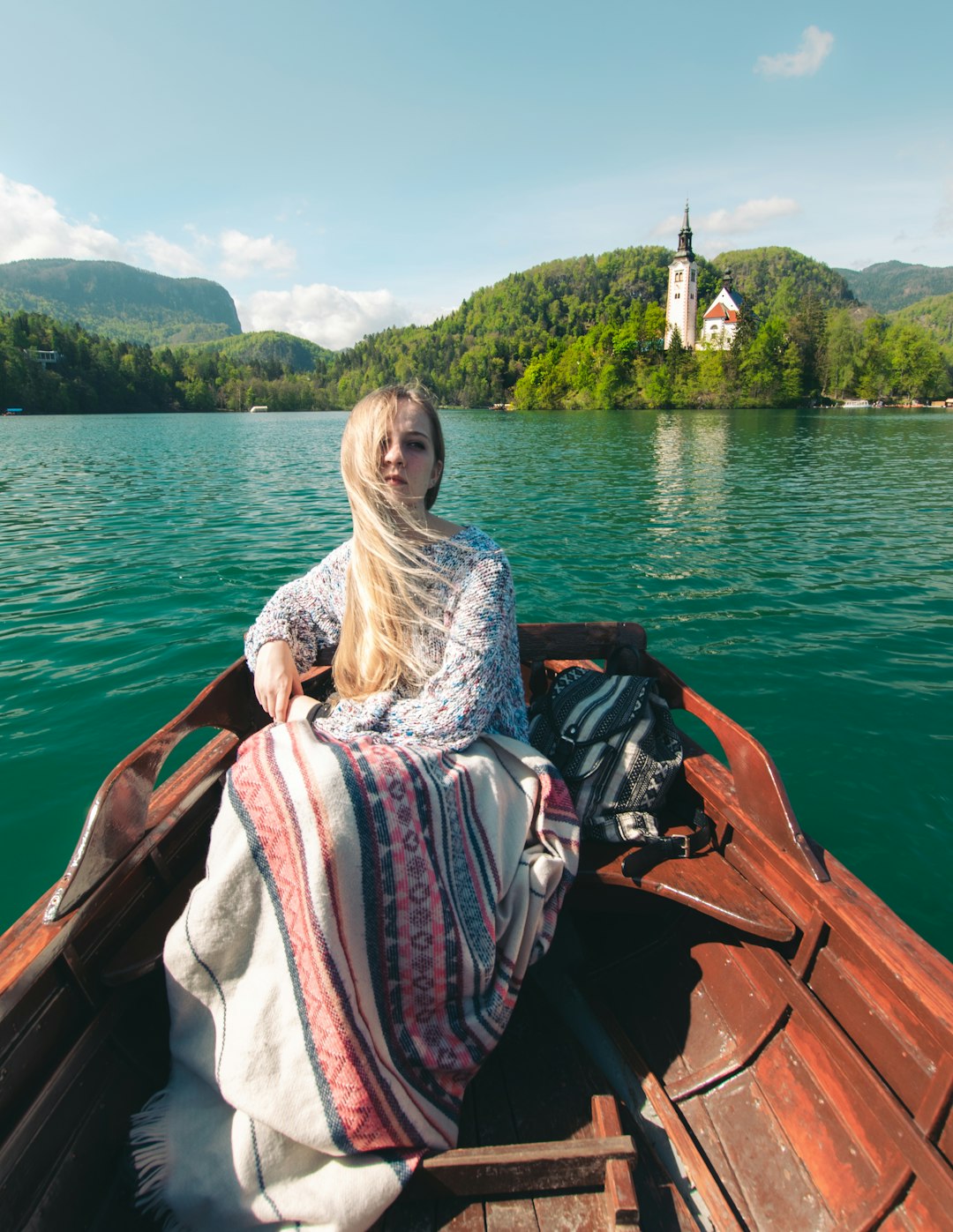 woman sitting in brown wooden boat in lake