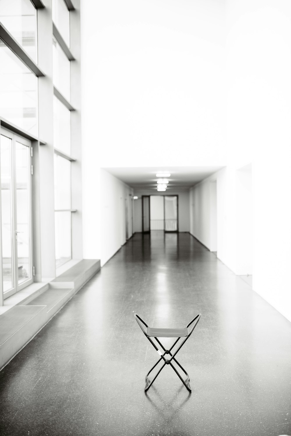 vacant white chair in between hallway of building