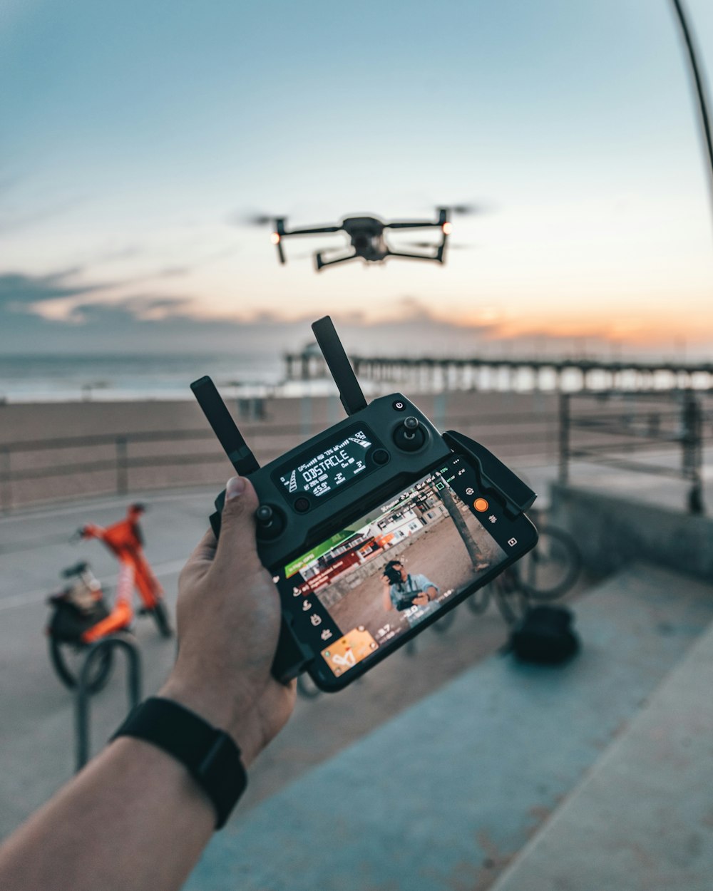 hombre que vuela un dron mientras sostiene el control remoto