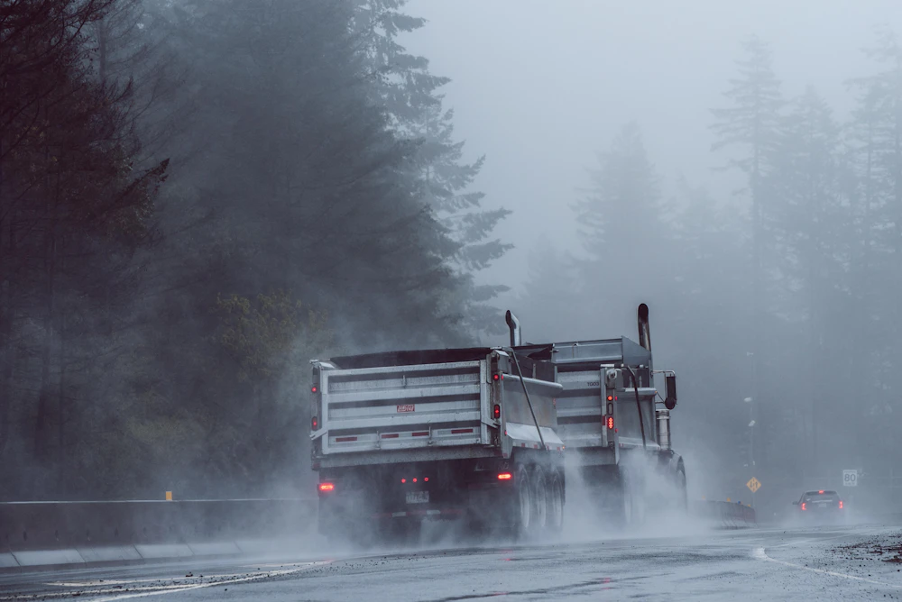 Lastbilar på en regnig väg