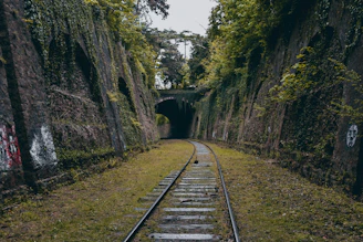 a train track going through a tunnel with graffiti on it