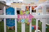 multicolored egg hunt decor on white wooden fence