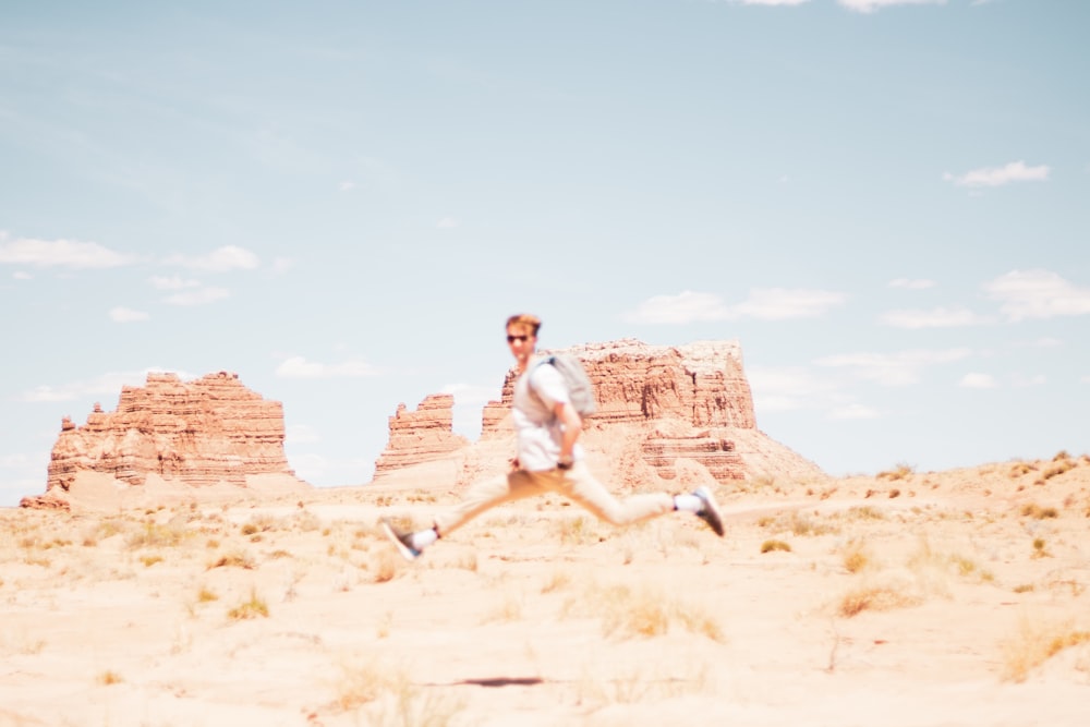 man hopping under clear blue sky