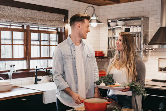 A friendly tradesperson discussing renovation plans with a homeowner in a bright, modern kitchen.