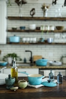 blue and white casserole near olive oil bottle on table