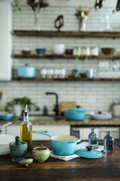 blue and white casserole near olive oil bottle on table