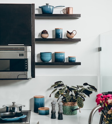 microwave beside containers on floating shelves