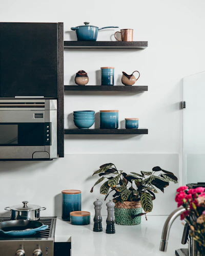 microwave beside containers on floating shelves