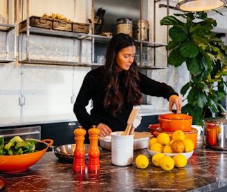 woman standing in front of fruits holding pot's lid