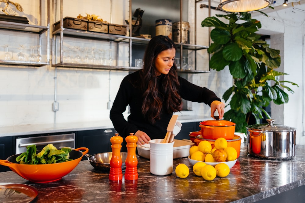 Femme debout devant des fruits tenant le couvercle du pot