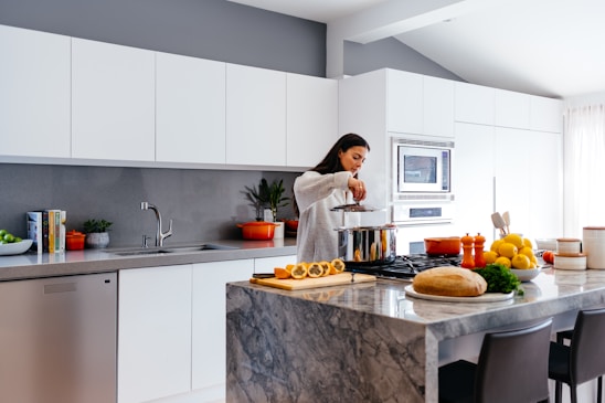 A bright, clean kitchen scene with a woman happily preparing colorful, healthy desserts.