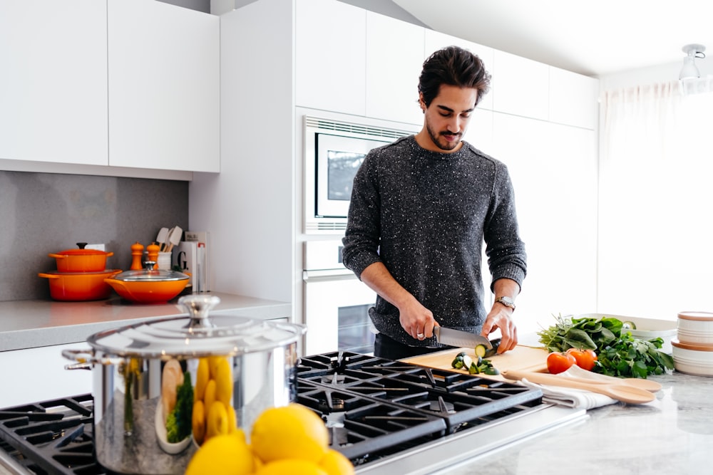 homme coupant des légumes