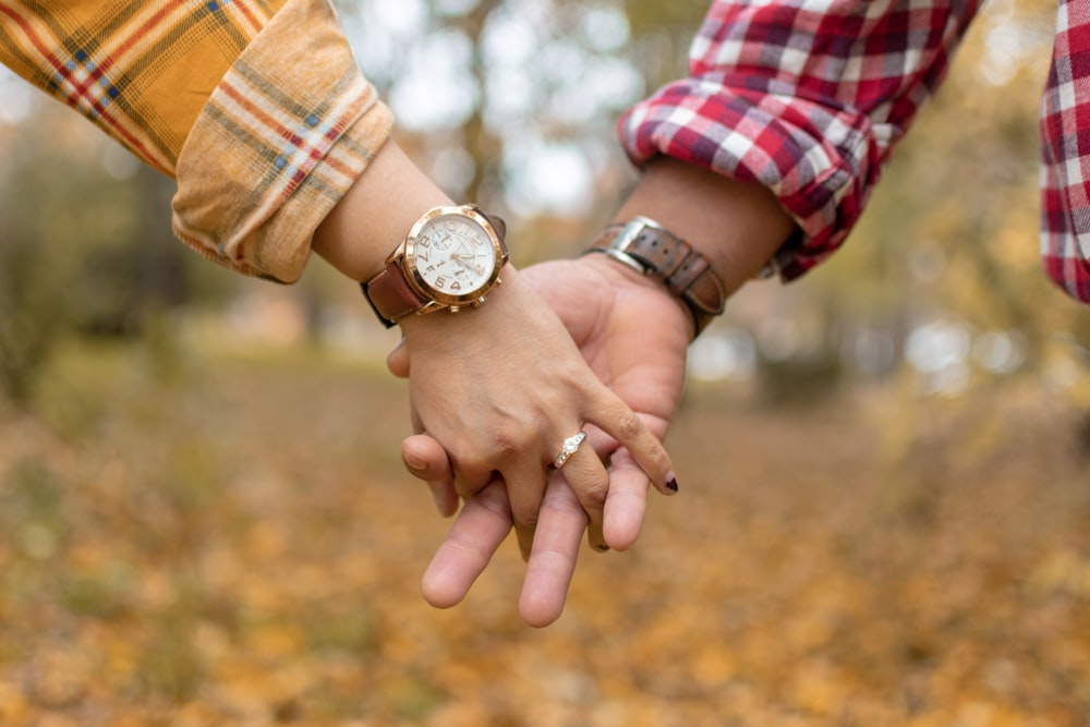 selective focus photography of man and woman holding hands