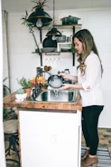 woman wearing white blouse washing dish on the faucet