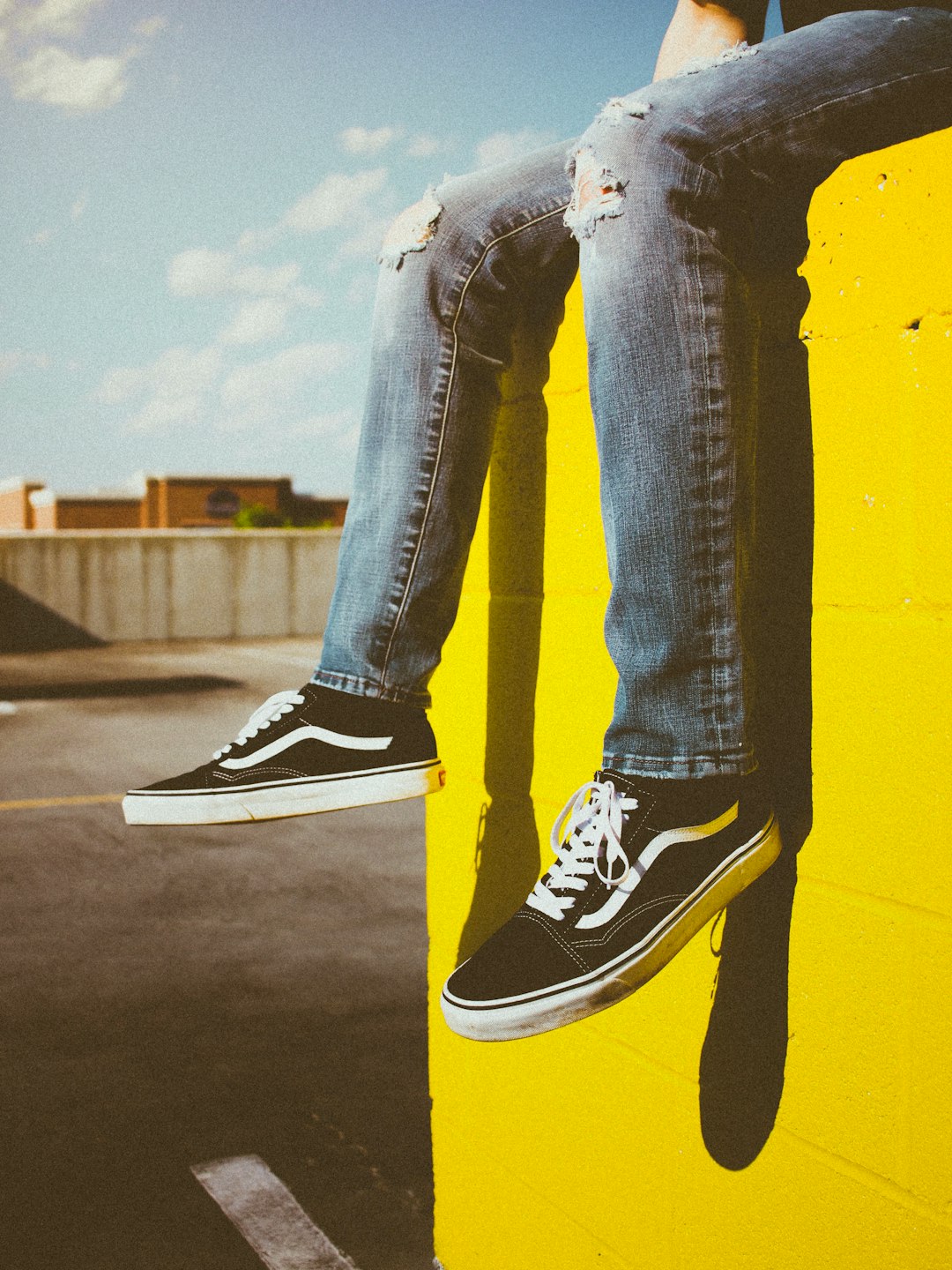 man sitting on yellow concrete fence