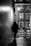 A shadowed figure walking down a dimly lit urban alley at night.