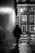 A shadowy figure walking down a dimly lit urban alley at night.