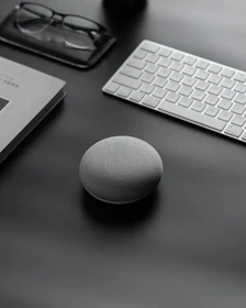 Close-up of sleek AI assistant devices on a minimalist desk.