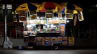 An inviting food cart illuminated by warm lights during a bustling evening market.