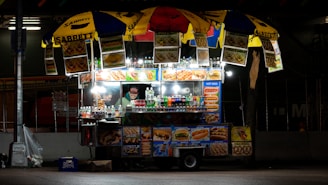 Photo of a vibrant street food cart with various snacks and drinks displayed.