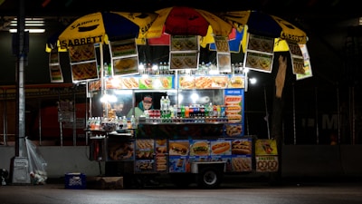 Close-up of a vibrant street food dish served from a colorful food cart.