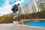 A dynamic shot of a streetboarder grinding along a metal rail in a skatepark.