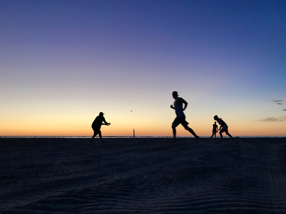 silhouette of men playing on ground