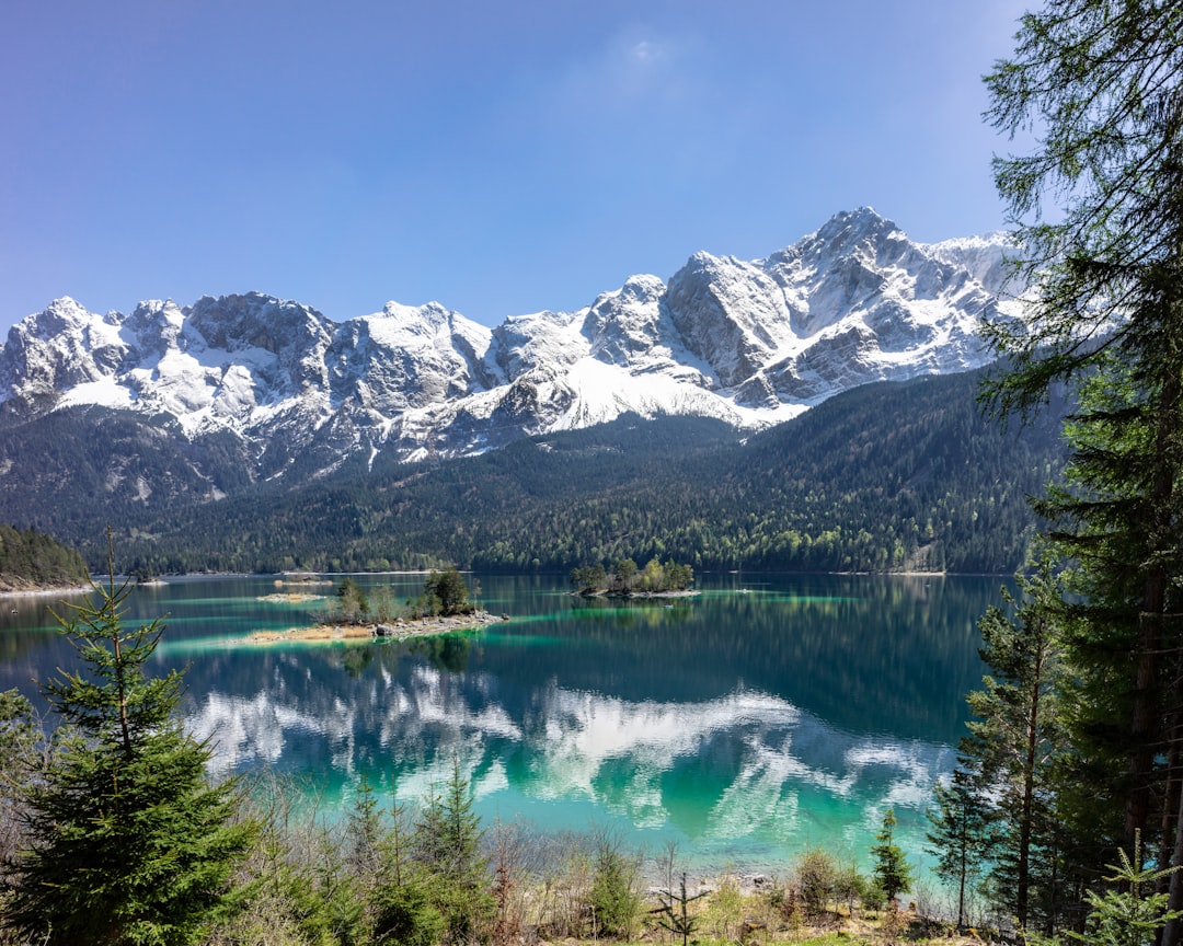 reflections of mountains on calm body of water