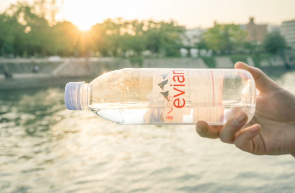 person holding clear plastic bottle during daytime