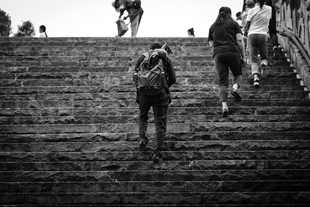 grayscale photography of people walking on stairway during daytime
