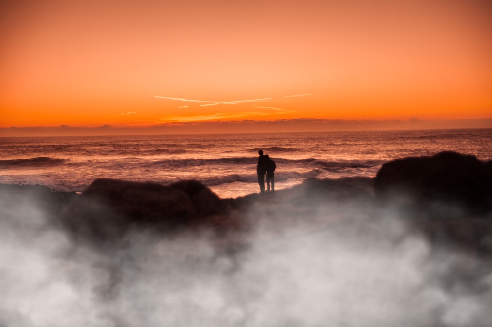 two people standing near shore