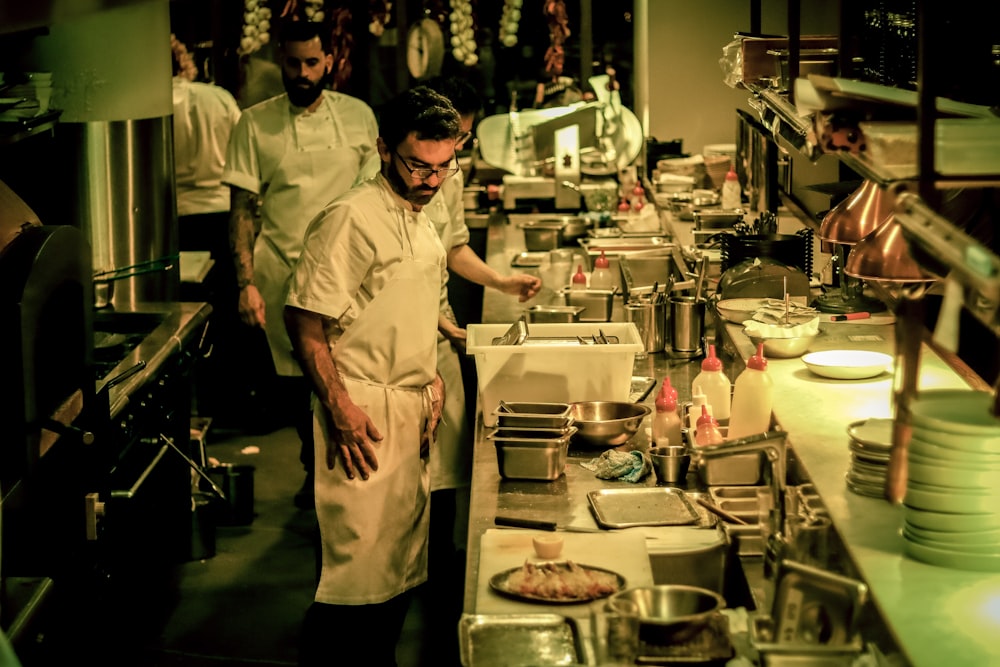 group of people standing inside kitchen