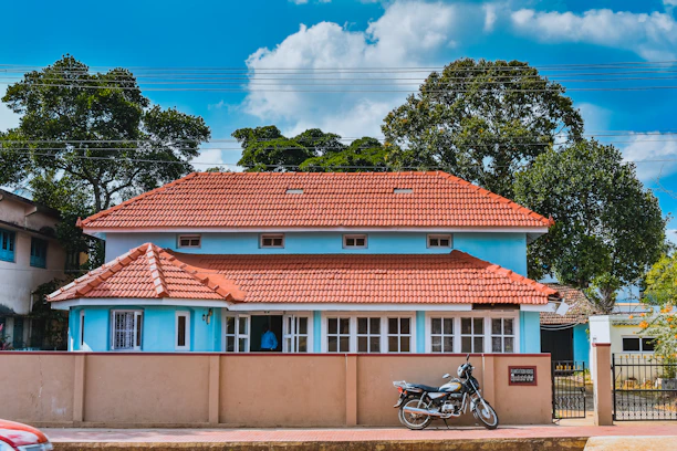 Traditional kost house exterior with neat garden and parked motorcycles