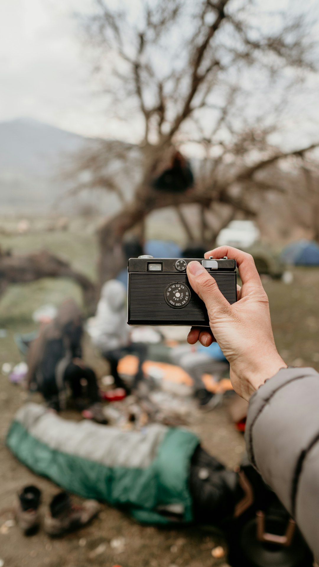 person holding black point-and-shoot camera