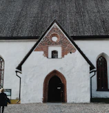 Stone facade and arched entrance of the antique barn in the historic courtyard.