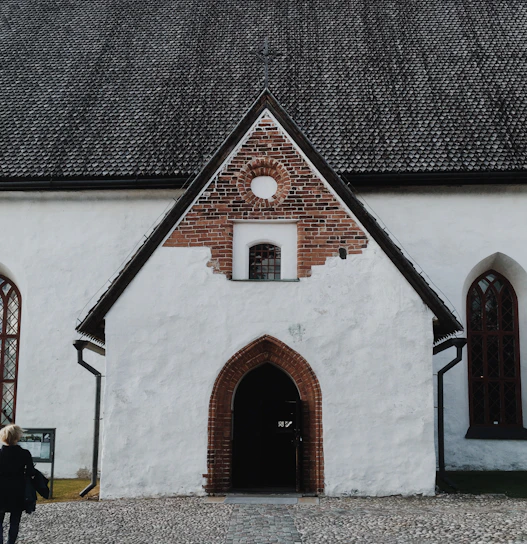 Stone facade and arched entrance of the antique barn in the historic courtyard.