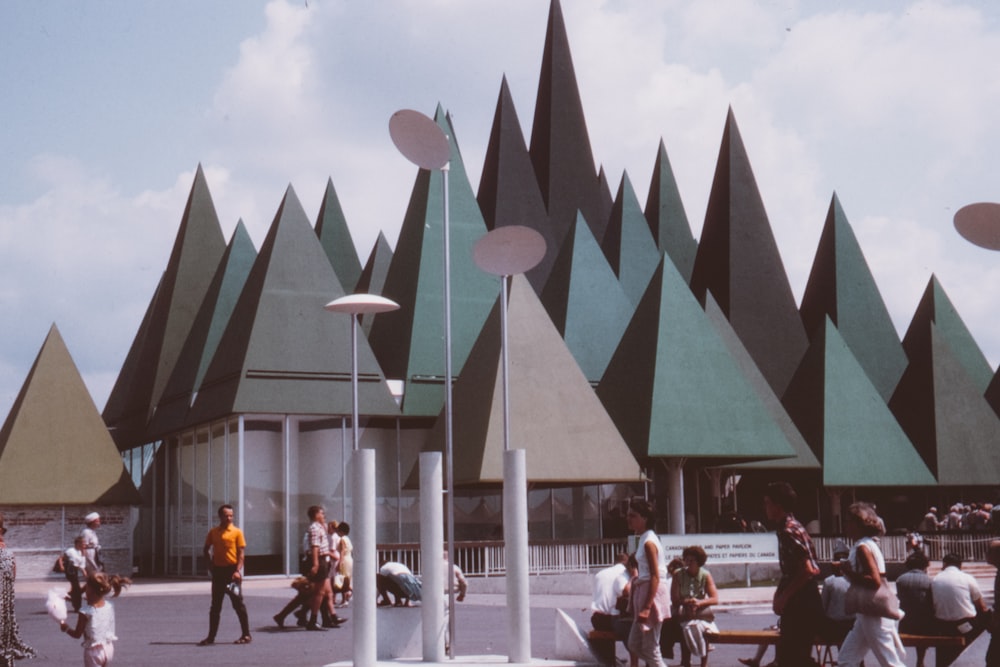 people near triangular shape building close-up photography