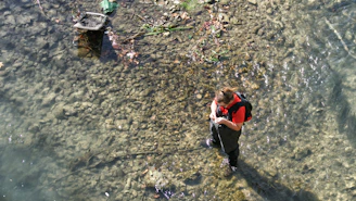 Reda inspecting water quality with testing equipment beside a calm pool.