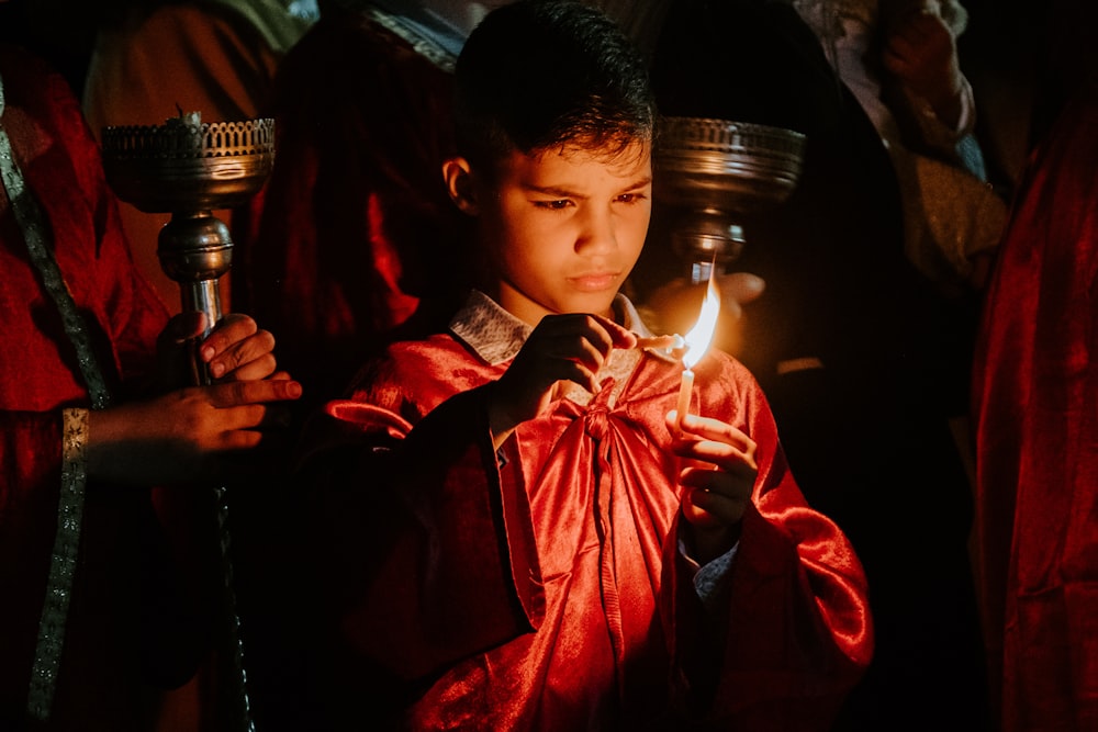 火のともった蝋燭を持つ少年