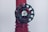 A close-up of a dark green valve wheel, mounted on a red pipe. The wheel has a central label with the word 'HYDRO'. The pipe has a textured surface with multiple facets and appears to be part of a larger industrial system.