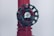 A close-up of a dark green valve wheel, mounted on a red pipe. The wheel has a central label with the word 'HYDRO'. The pipe has a textured surface with multiple facets and appears to be part of a larger industrial system.