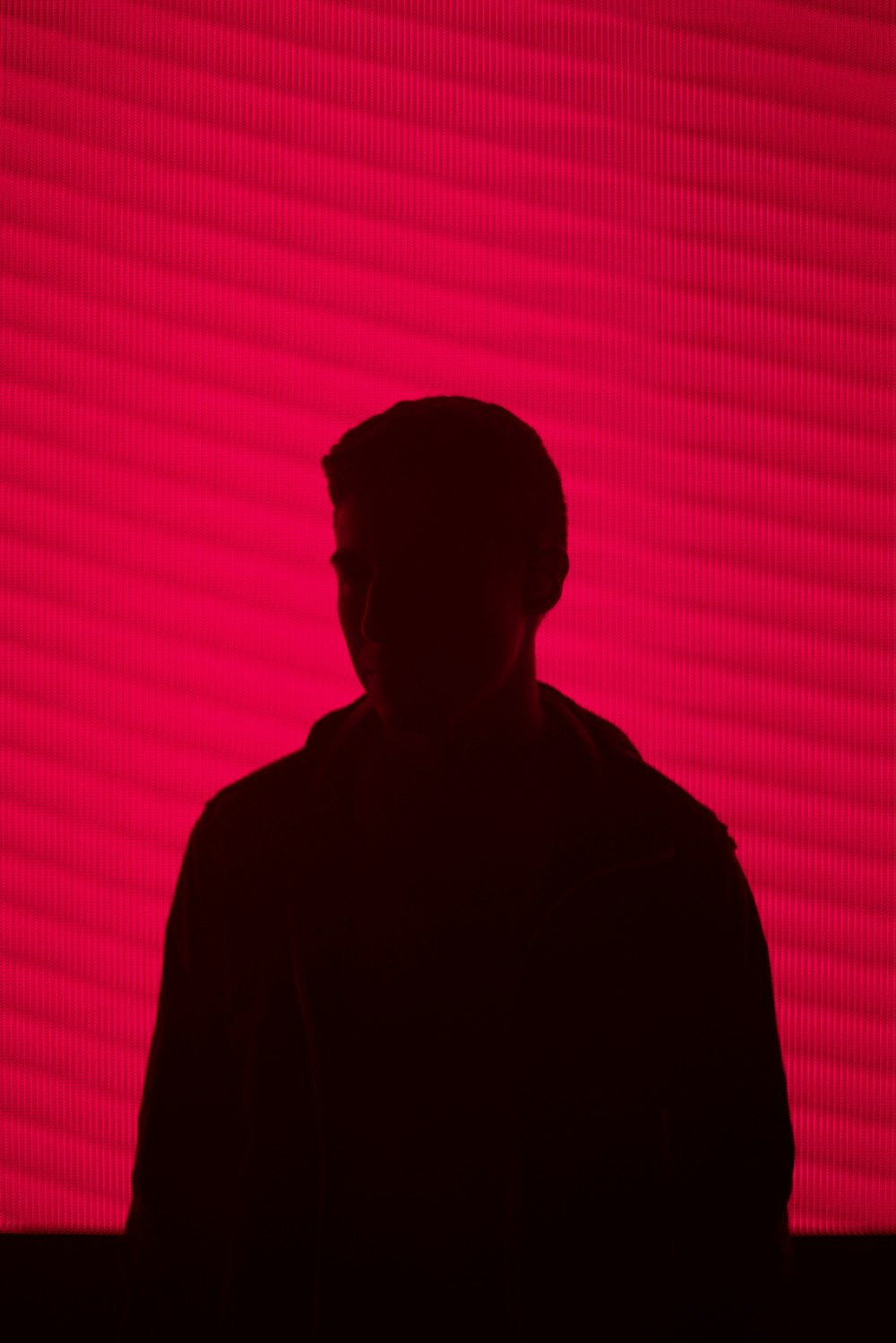 man standing against red wall