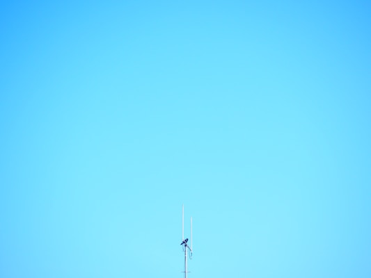 a tall antenna on top of a tall building