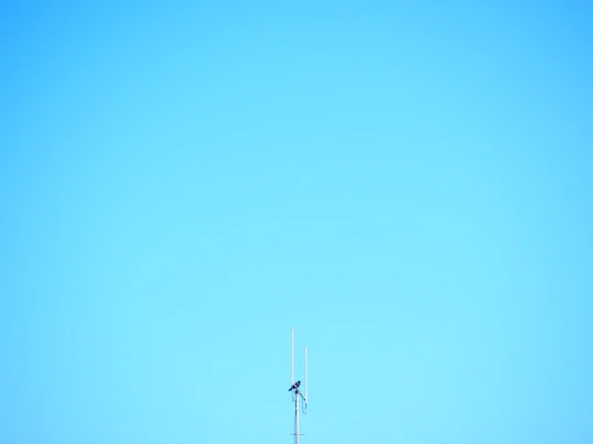 a tall antenna on top of a tall building